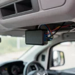 Boîtier de géolocalisation installé sous le tableau de bord d'un utilitaire