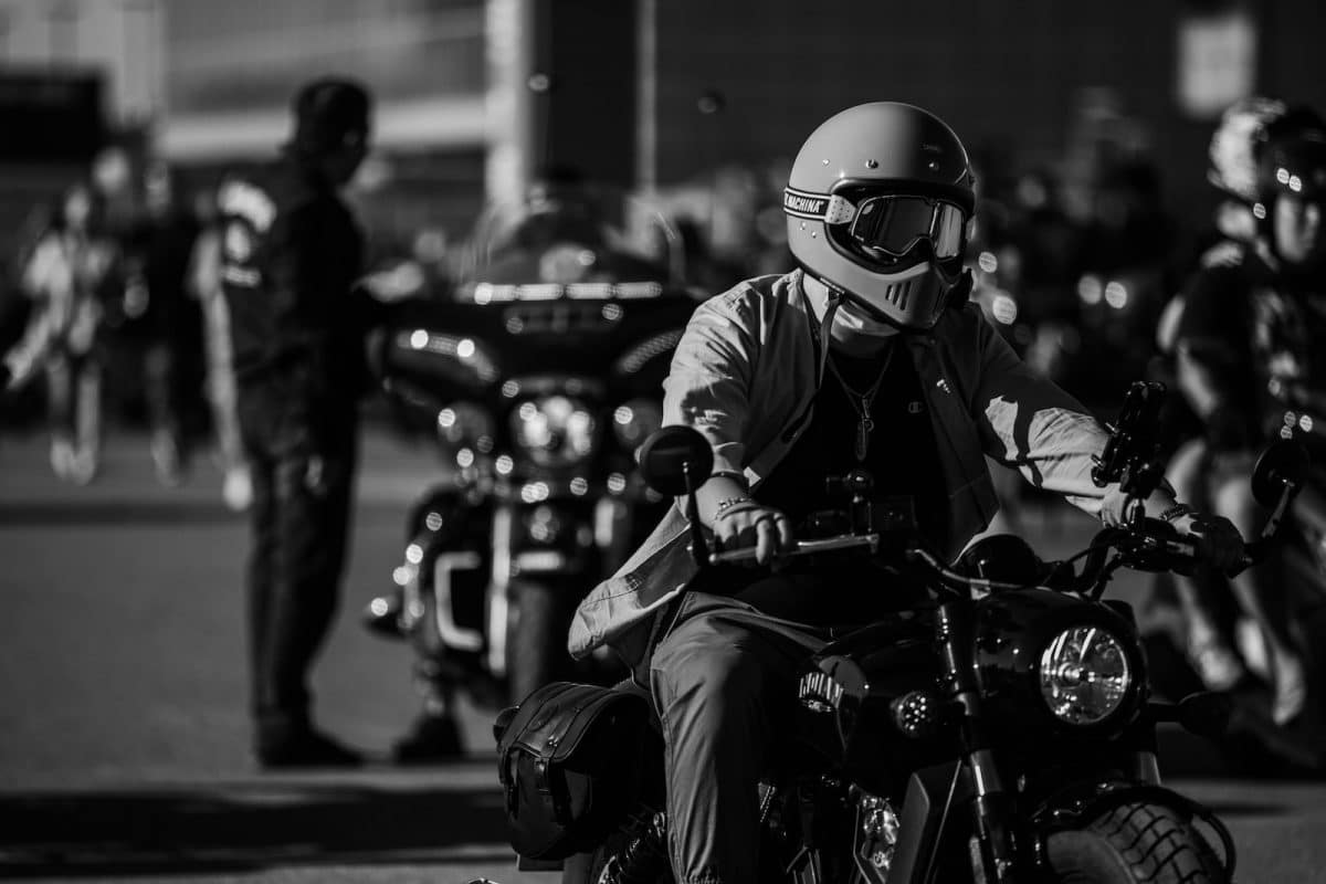 grayscale photo of man riding motorcycle