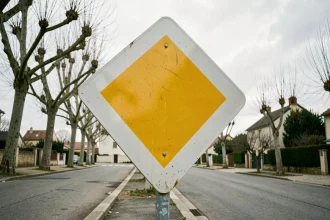 Panneau de priorité losange jaune et blanc sur poteau métallique en zone résidentielle française