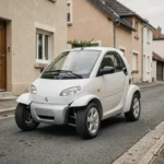 Voiture sans permis 4 places blanche garée dans une rue résidentielle française, vue de trois quarts avant